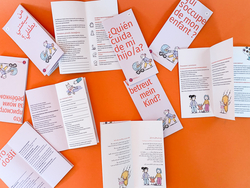 Der Flyer &bdquo;Wer betreut mein Kind?&ldquo; liegt in verschiedenen Sprach-Versionen teil aufgeklappt auf einer orangefarbenen Fl&auml;che. 