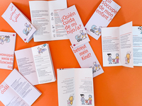Der Flyer „Wer betreut mein Kind?“ liegt in verschiedenen Sprach-Versionen teil aufgeklappt auf einer orangefarbenen Fläche. 